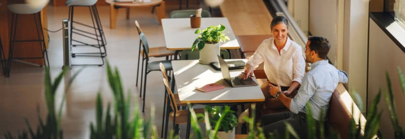 Un homme et une femme en pleine séance de brainstorming dans un espace de coworking chaleureux 