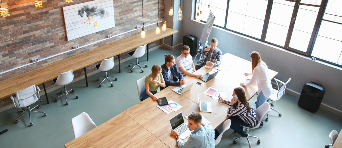 Une réunion dans un espace de coworking, table en bois et ampoules design