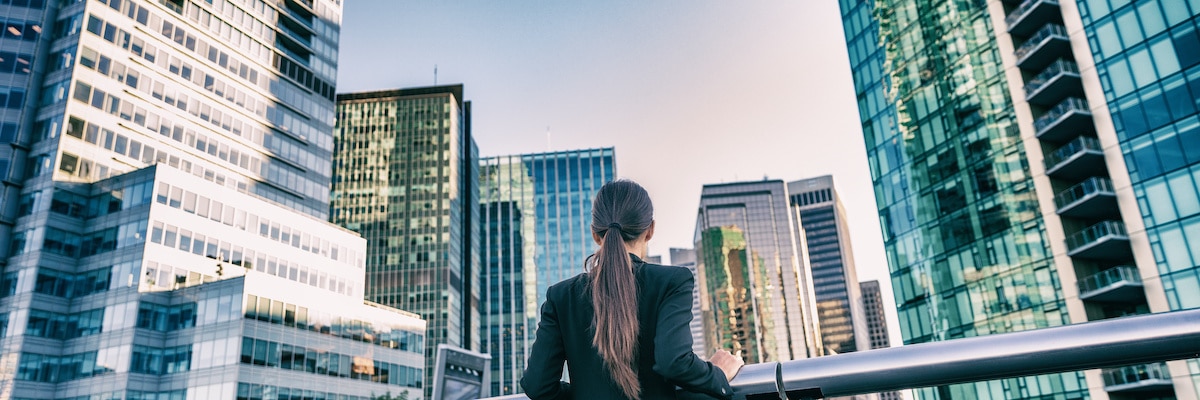 Une jeune femme observe les buildings, la gestion immobilière est améliorée par le flex office 