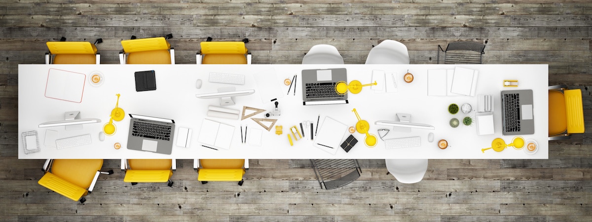 Un table avec des sièges jaunes prête à recevoir une réunion collaborative