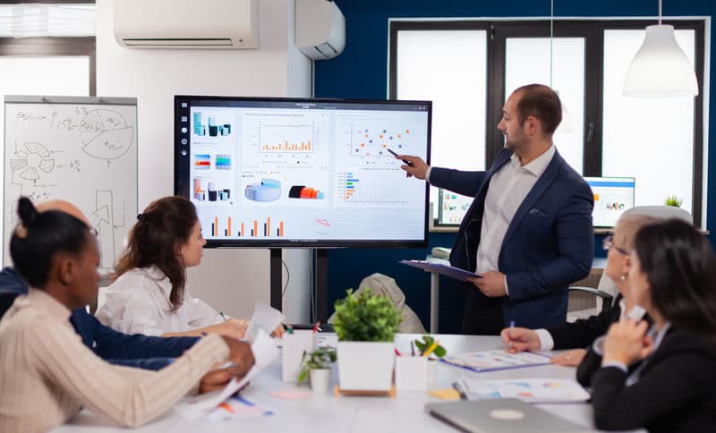 Personne qui anime une réunion avec un powerpoint