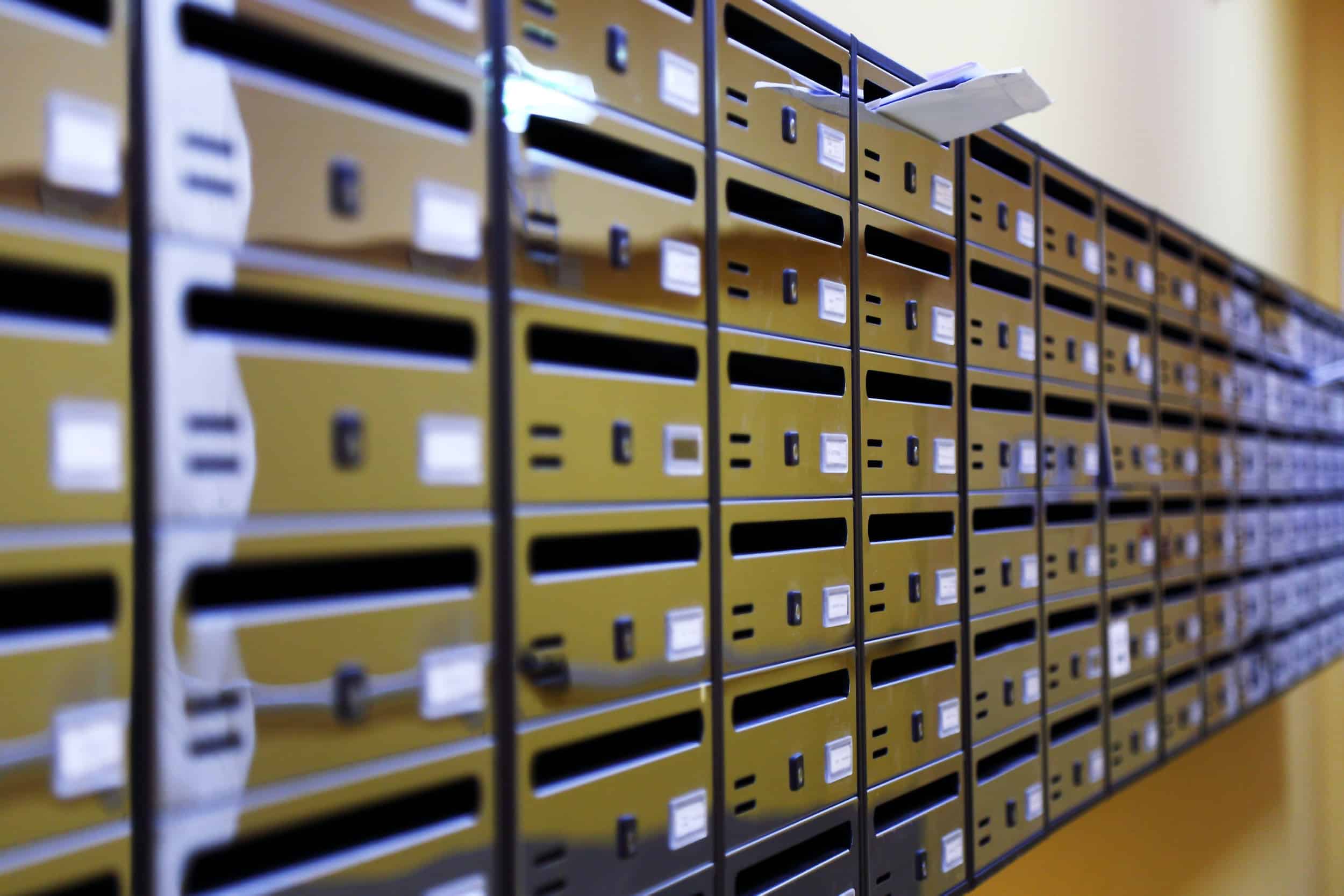 rangées de boîtes aux lettres dont une où dépasse du courrier